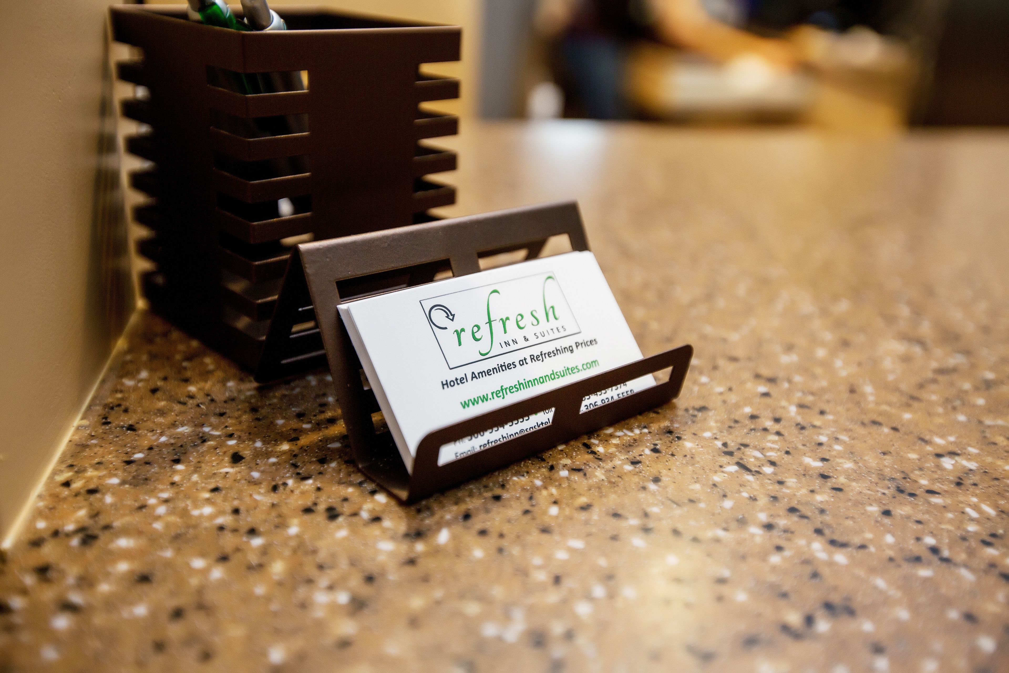 Carte de visite de l’établissement Refresh Inn & Suites, indiquant l’adresse du site web et les numéros de téléphone.
