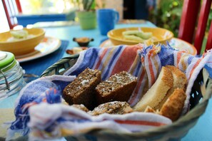 Un panier de pain et un saladier de fruits sur une table.