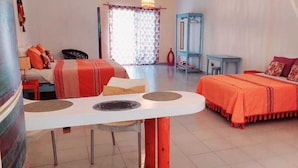 Ein Hotelzimmer mit einem Bett, einem Esstisch, einem Stuhl, einem kleinen Tisch und einem Kleiderschrank.