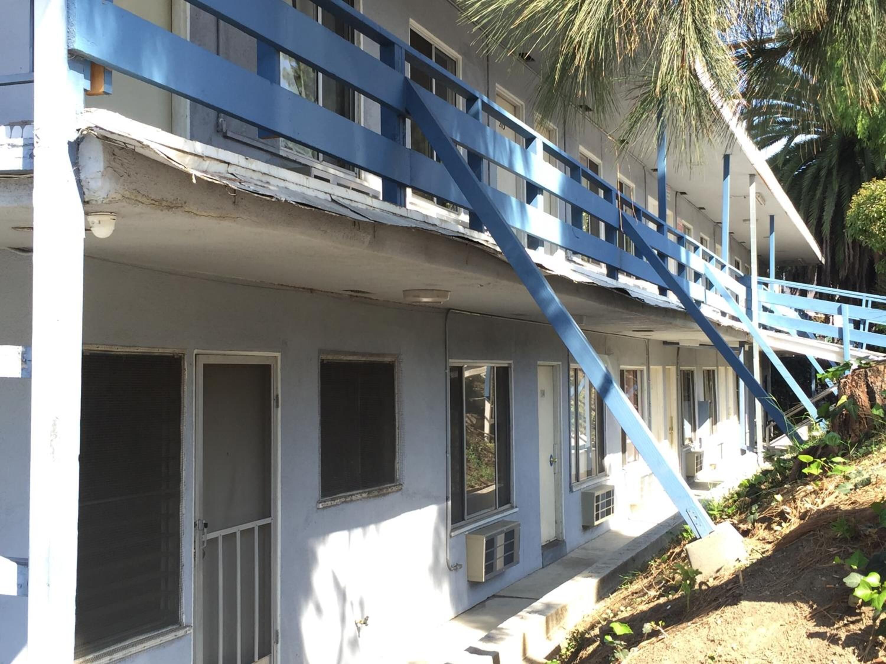 A building with a blue staircase leading to a balcony.