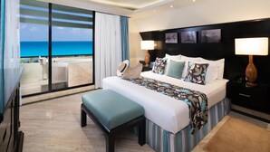 A hotel room with a large bed, a bench, a nightstand, and a view of the ocean. - The Pyramid Cancun by Oasis - Gourmet Premium All Inclusive (Cancun)