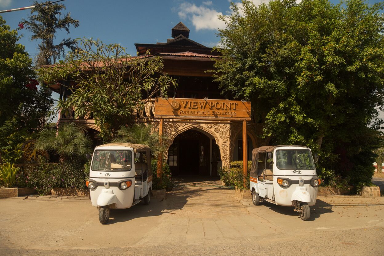 A traditional building with an ornate entrance labeled "VIEWPOINT Restaurant & Eco Lodge." Two tuk-tuks are parked in front.