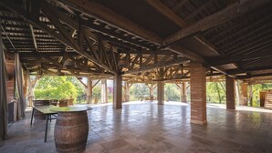 An open pavilion with a tiled floor, wooden beams, and brick pillars. - Château de Loubéjac (L'Honor-de-Cos)