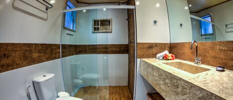 A modern bathroom with a glass-enclosed shower, a white toilet, and a marble sink.
