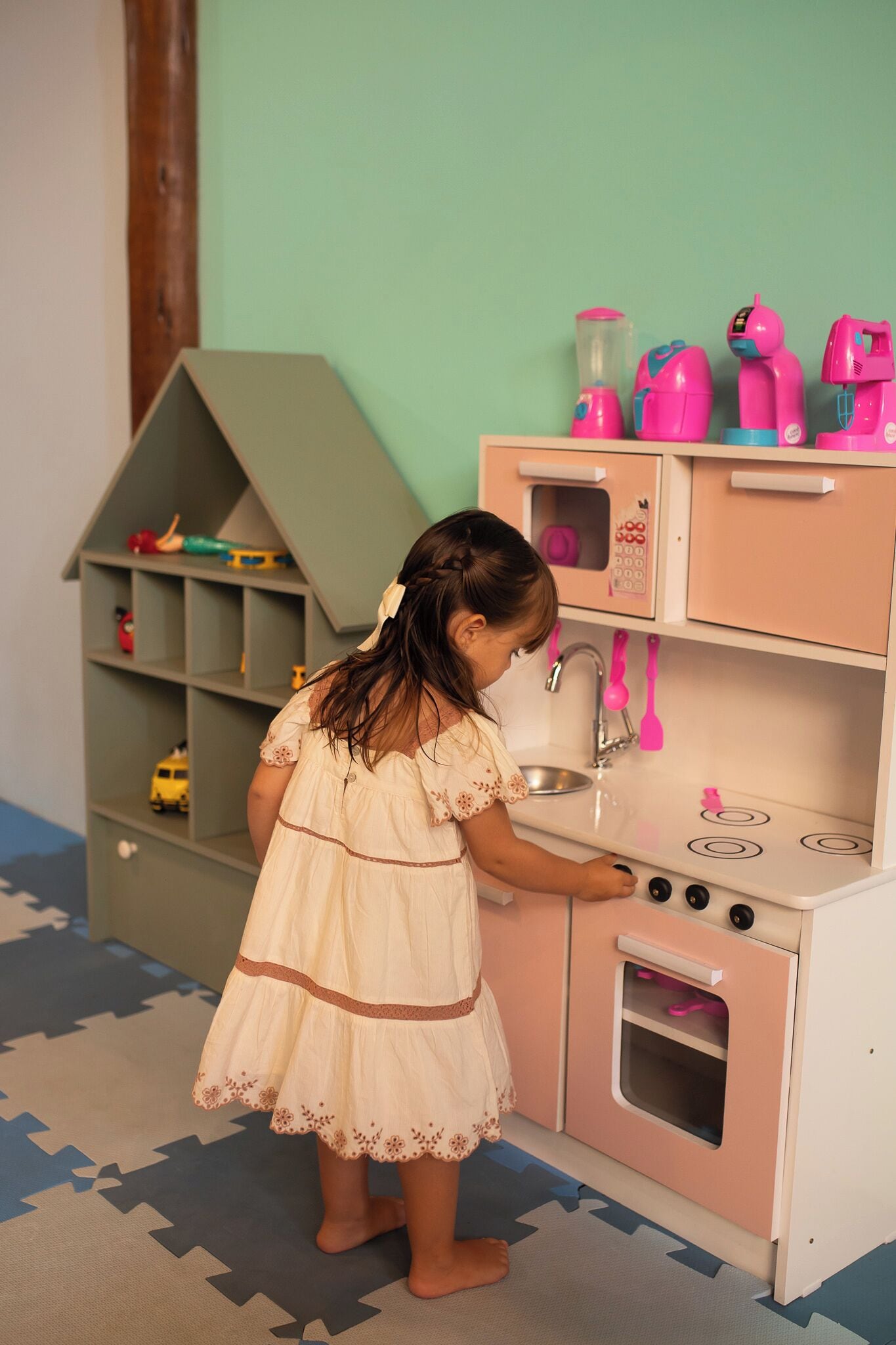 A child playing with a toy kitchen set.