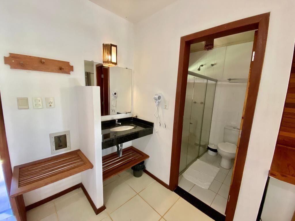 A bathroom with a sink, mirror, and shower.