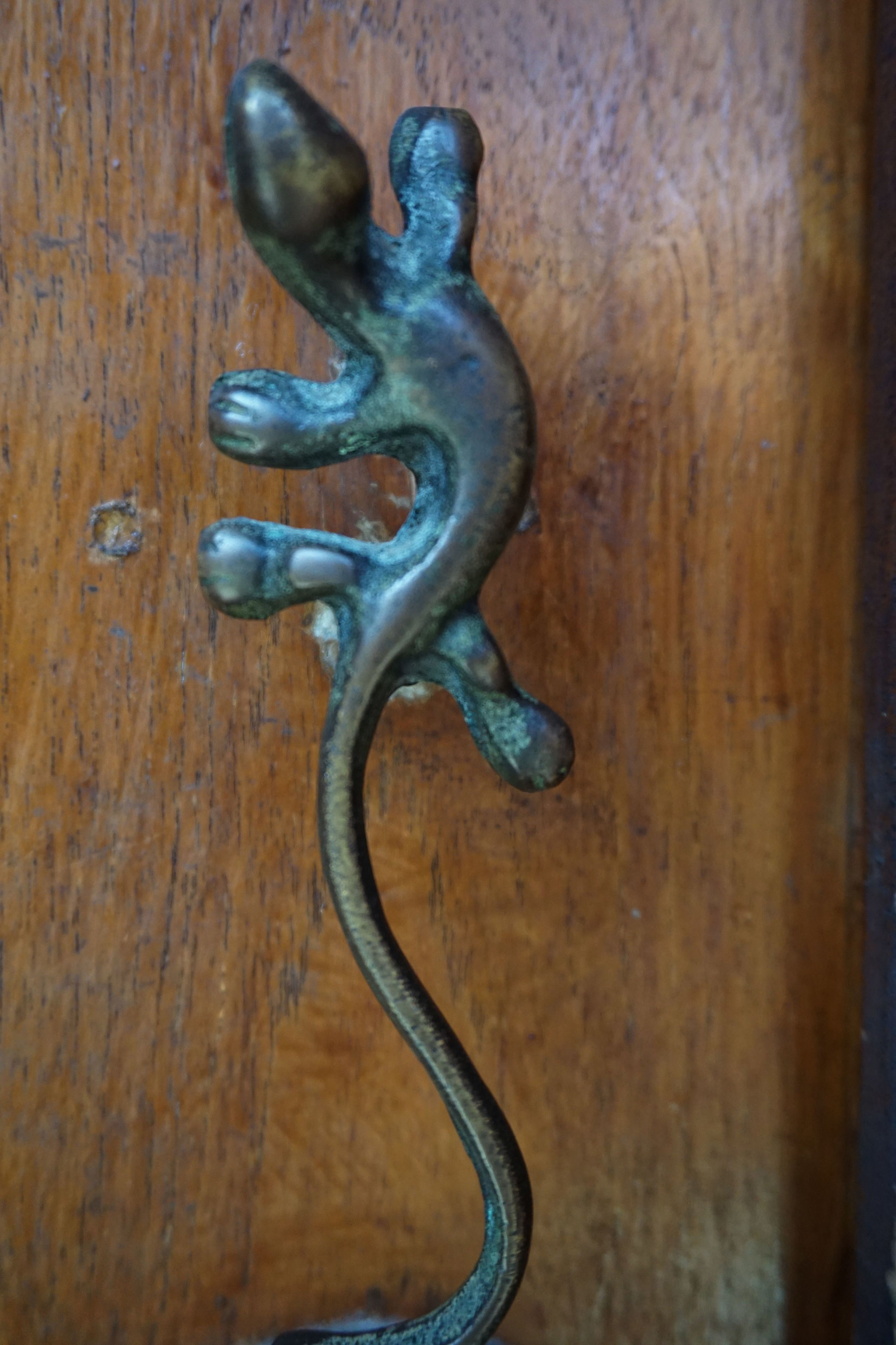 Close-up van een houten oppervlak met een object in de vorm van een hagedis, gemaakt van metaal.