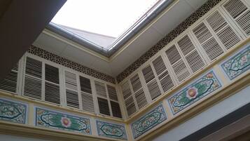A corner of a building with decorative moldings and a skylight.