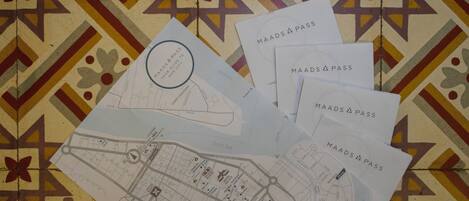 A map with a compass rose, a city layout, and several 'MAADS PASS' cards.