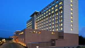 Un hôtel moderne à l’architecture imposante, avec de nombreuses fenêtres et une entrée bien éclairée.
