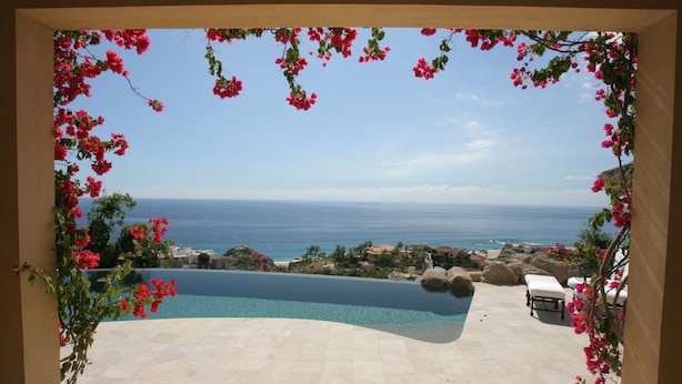 Vista a la piscina con una vista despejada del océano y una costa distante.