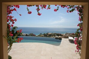 Vista a la piscina con una vista despejada del océano y una costa distante.