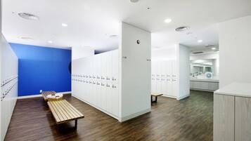 Relax and unwind in this locker room with a wooden bench and ample storage space.