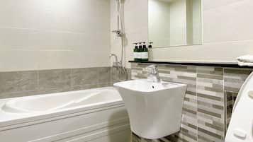 A modern bathroom with a bathtub, sink, and toilet.