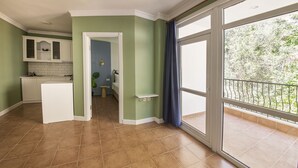Una cocina amplia con un refrigerador blanco, un horno empotrado y ventana con vista a un balcón.