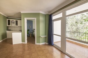 Una cocina amplia con un refrigerador blanco, un horno empotrado y ventana con vista a un balcón.