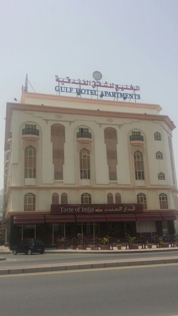 A building with a sign reading 'Gulf Hotel Apartments' and 'Taste of India' restaurant.
