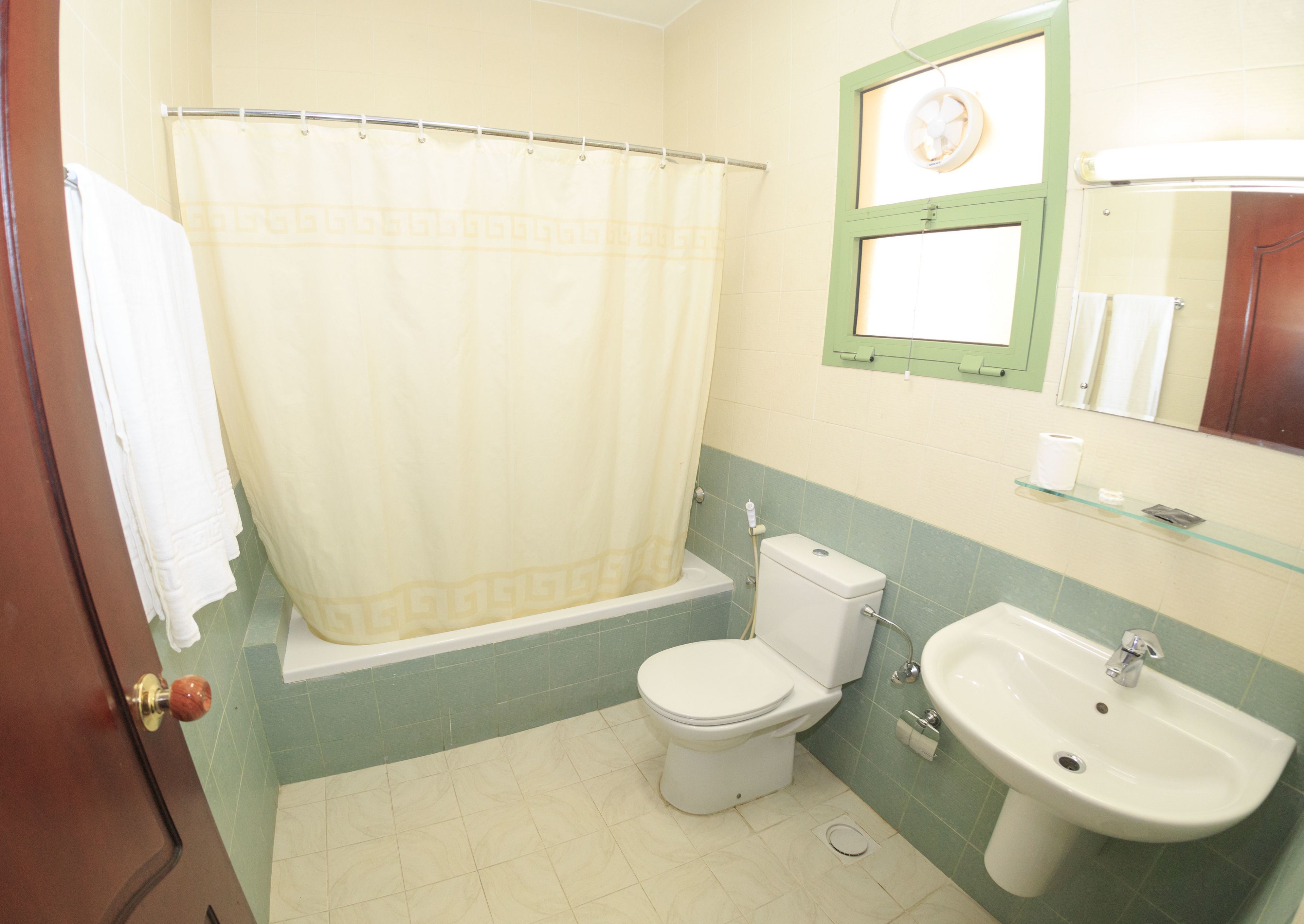 Ein Badezimmer mit Toilette, Waschbecken und Duschvorhang.