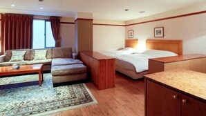 A hotel room with a sofa, a small table, a bed, and a cabinet. - Gimcheon Park Tourist Hotel (Gimcheon)