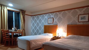 A hotel room with two beds, a desk with a chair, a lamp, and a window with curtains. - Gimcheon Park Tourist Hotel (Gimcheon)