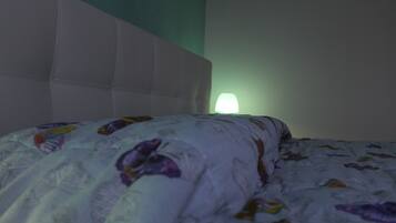 A bed with a patterned blanket and a headboard.