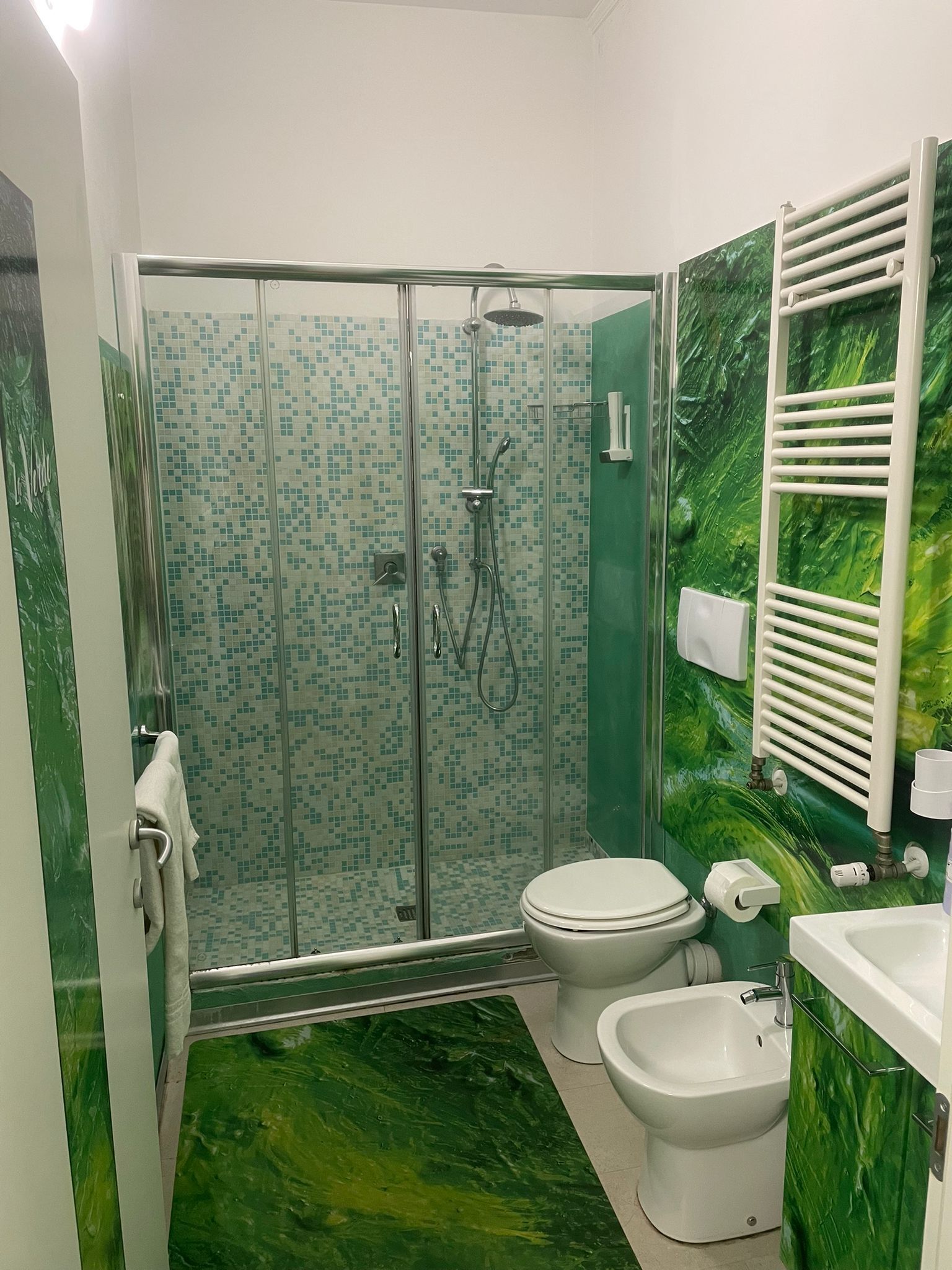 Un bagno con doccia, toilette, bidet e lavandino.