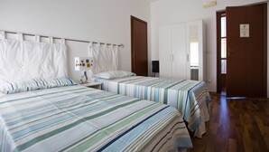A hotel room with two beds, a wardrobe, a desk, and a bathroom. - Il Paesino (Licodia Eubea)
