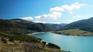 A panoramic view of a lake surrounded by hills and greenery. - Il Paesino (Licodia Eubea)