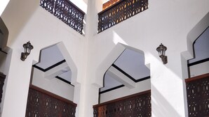 A multi-level interior with white walls and wooden balconies. - Forodhani Park Hotel (Zanzibar Town)