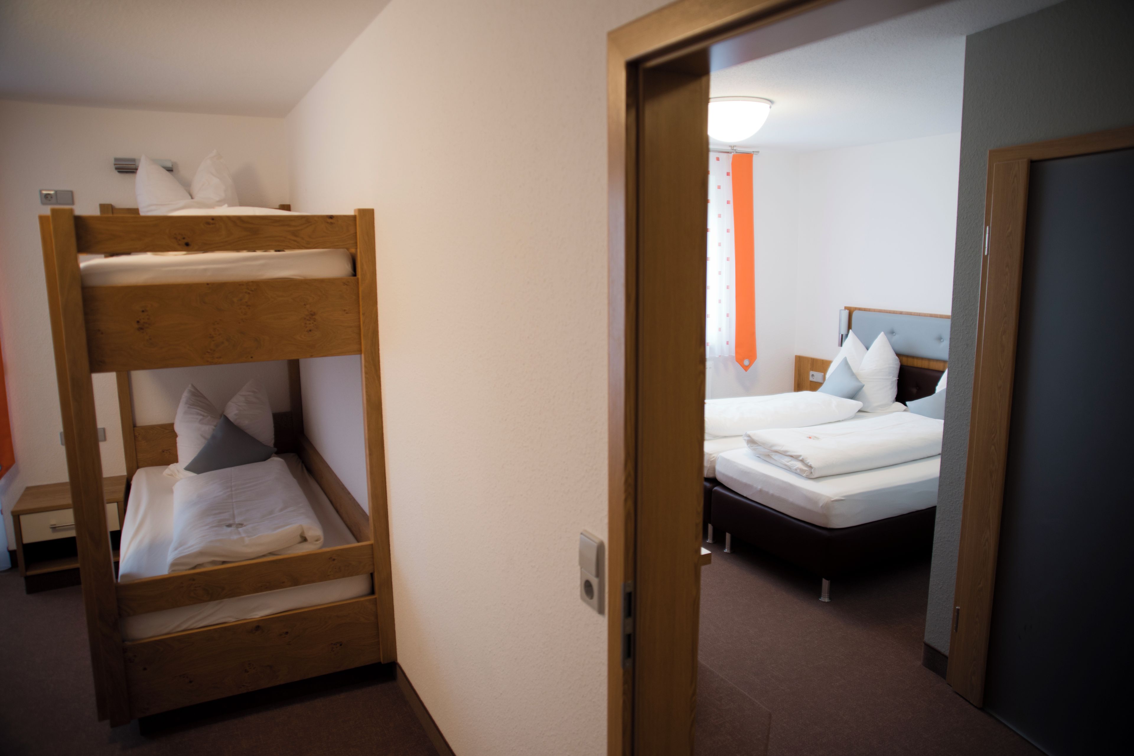 Ett hotellrum med en våningssäng och en enkelsäng.