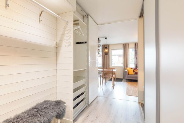 A hallway leading to a living area with a sofa, chairs, and a rug.