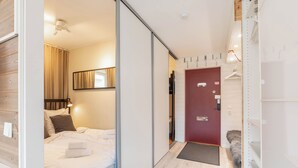 A modern hotel room with a bed, a wardrobe, a mirror, and a red door. - Åre Travel - Center (Are)