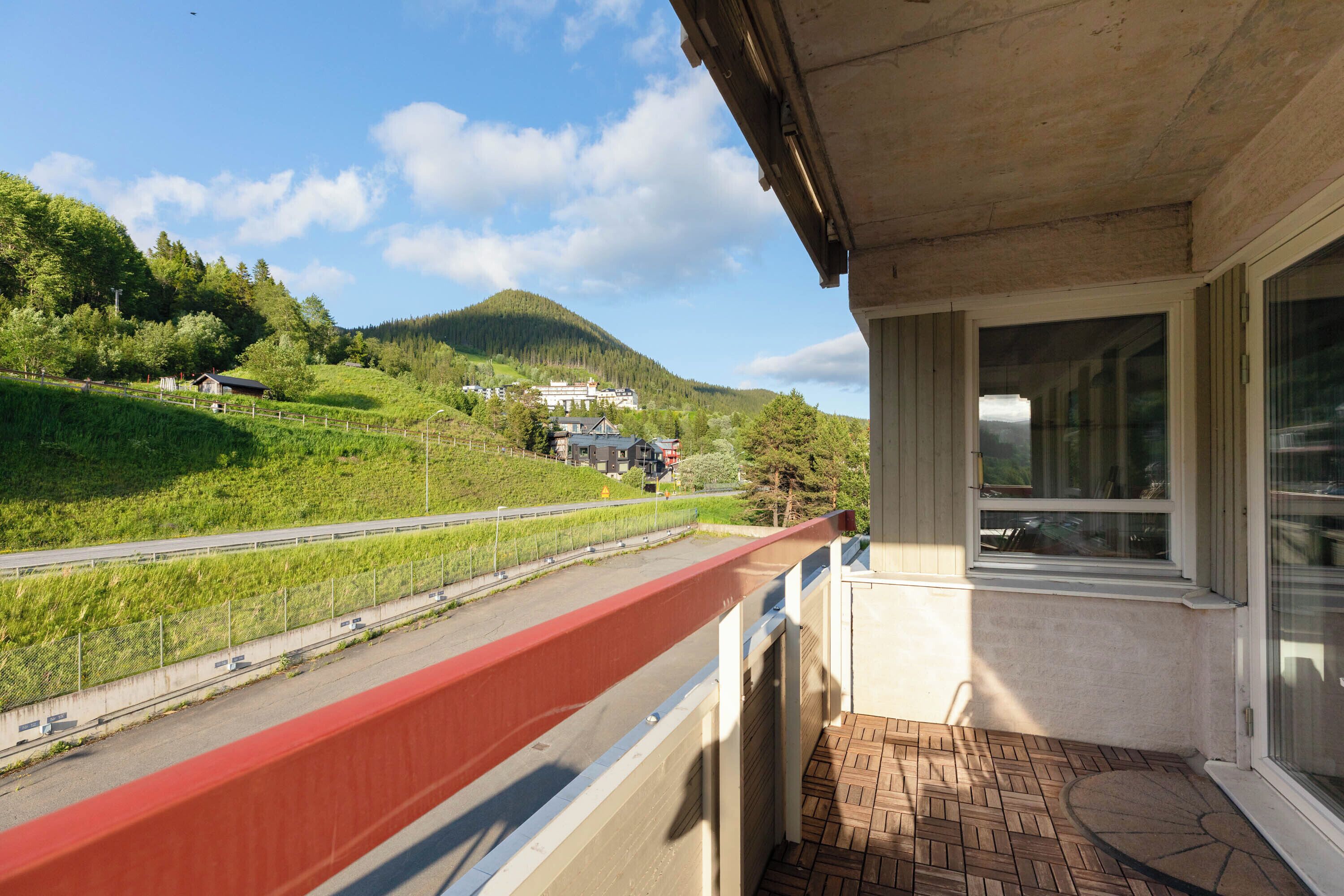 A balcony with a view of a road and a mountain.