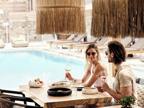 A dining table with a bowl of salad, a glass of wine, and a bowl of fruit. - Mykonos No5 (Mykonos)