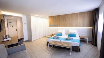 Een moderne hotelkamer met een bed, een bureau, een stoel en een kledingkast.