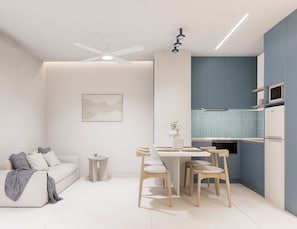 Une cuisine moderne avec un coin repas, un ventilateur de plafond et une petite table d’appoint.