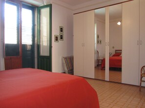 Une chambre à coucher avec un lit, une armoire et un miroir.