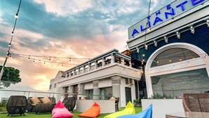 A hotel with a balcony, outdoor seating, and a sign that reads "ATLANTE". - The Aliante Hotel (Malang)