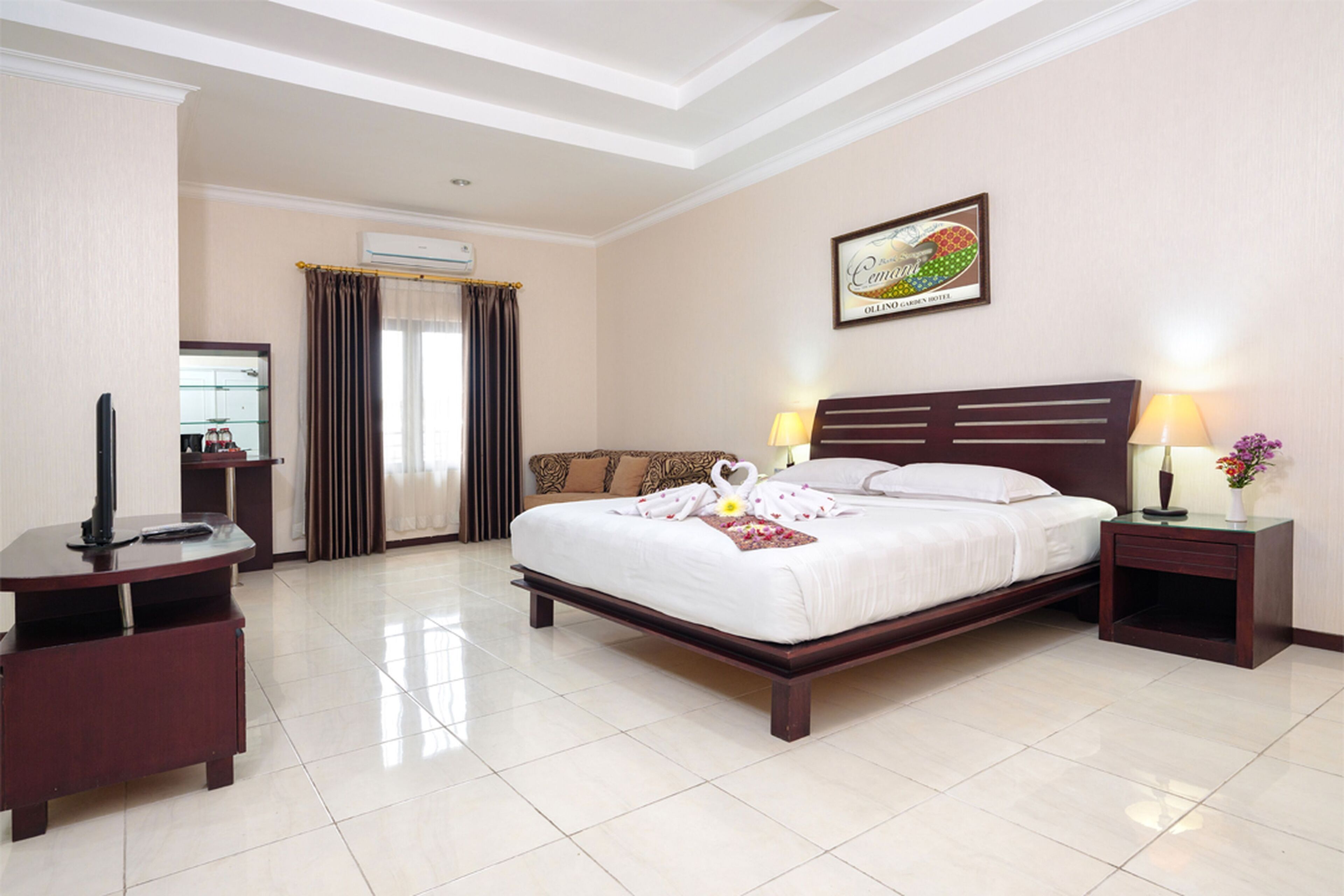 A hotel room with a large bed, two bedside tables with lamps, a flat-screen TV, a desk with a chair, and a mirror.