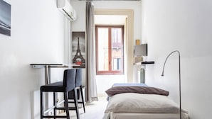 A compact room with a bed, a desk with a chair, a TV on a stand, and a window with a view of the Eiffel Tower. - Catania Inn (Catania)