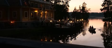 A lakeside building with outdoor seating and a dock.