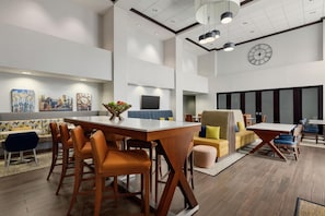 A modern interior with a dining area, seating, and artwork on the walls. - Hampton Inn & Suites Pittsburgh/Harmarville (Pittsburgh)