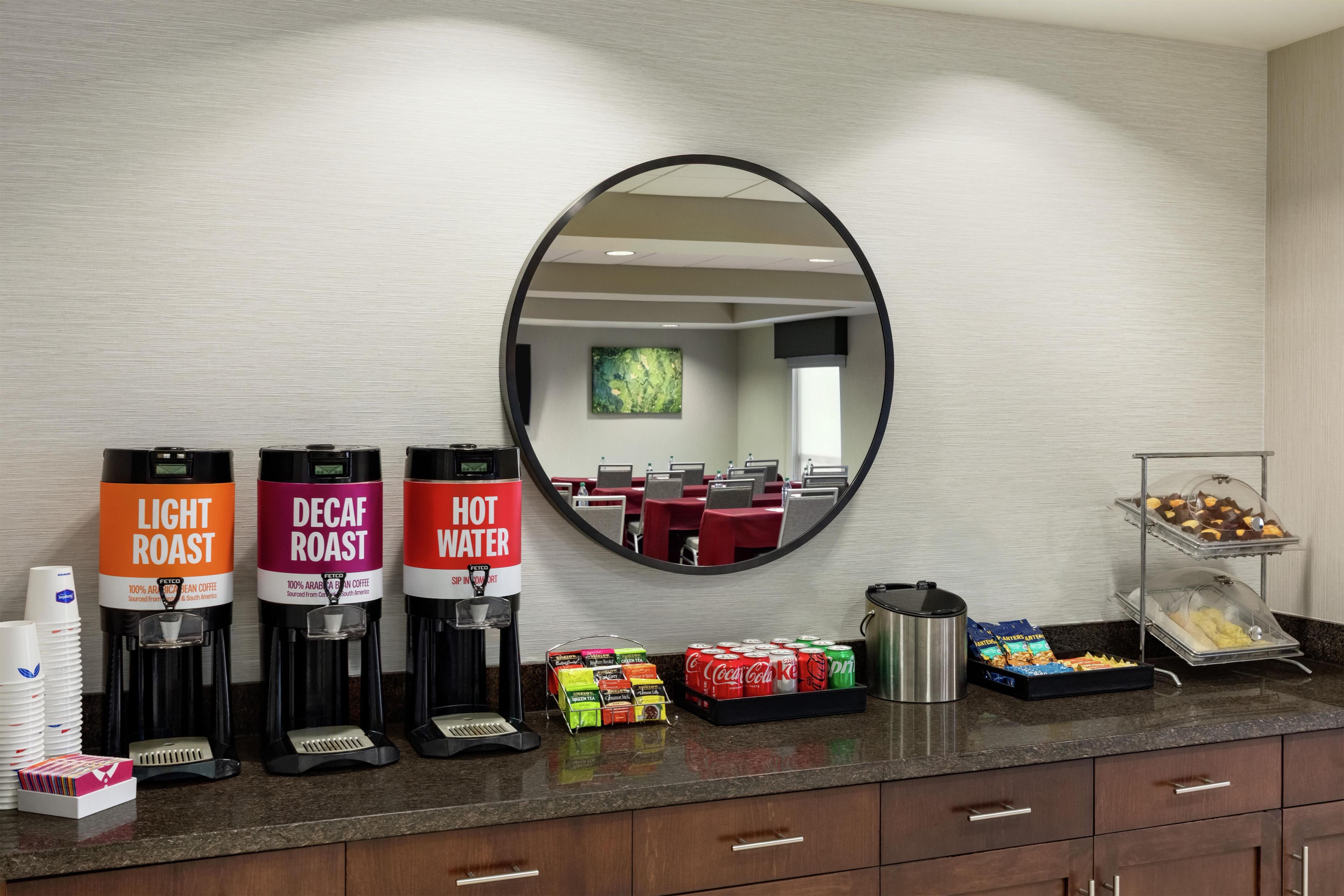 Habitación de hotel con estación de café que ofrece café de tueste claro, descafeinado y agua caliente.