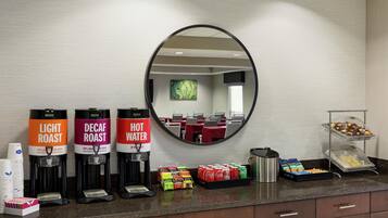 Habitación de hotel con estación de café que ofrece café de tueste claro, descafeinado y agua caliente.