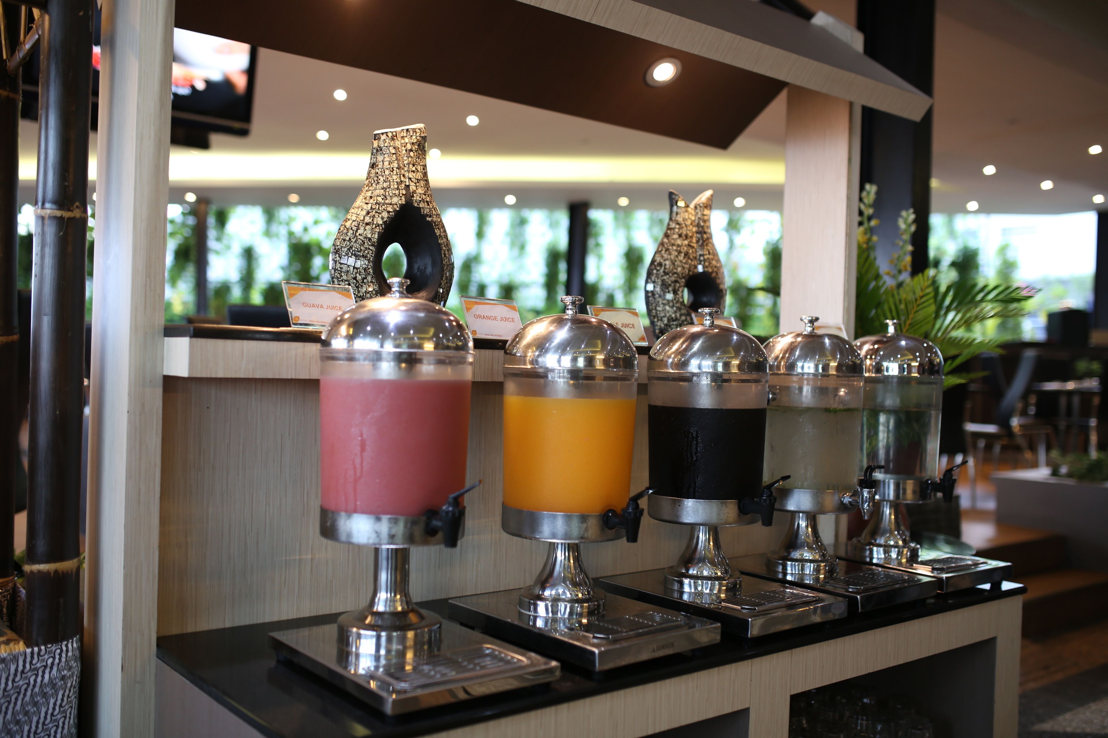 A juice bar with four dispensers, each labeled with a different juice type.