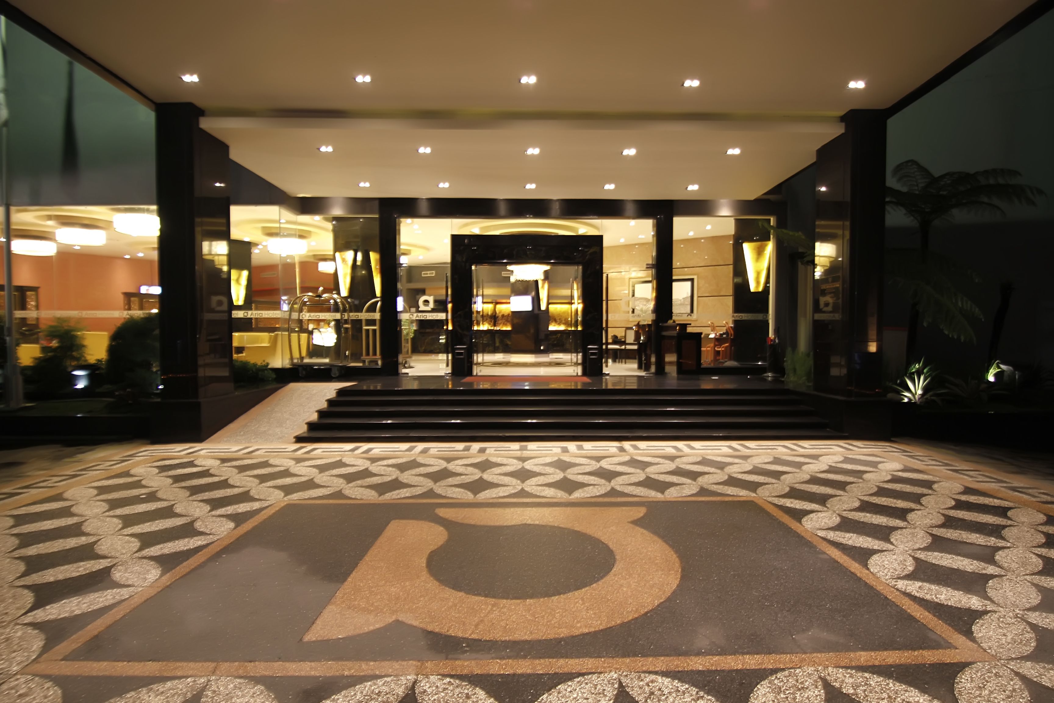 A hotel entrance with a geometric patterned floor and a large 'P' symbol.