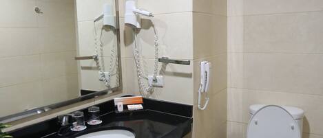 A bathroom with a black sink, a white toilet, and a mirror.