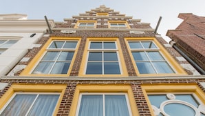 Un edificio de fachada simétrica, con una sección central de amplias ventanas y detalles decorativos.