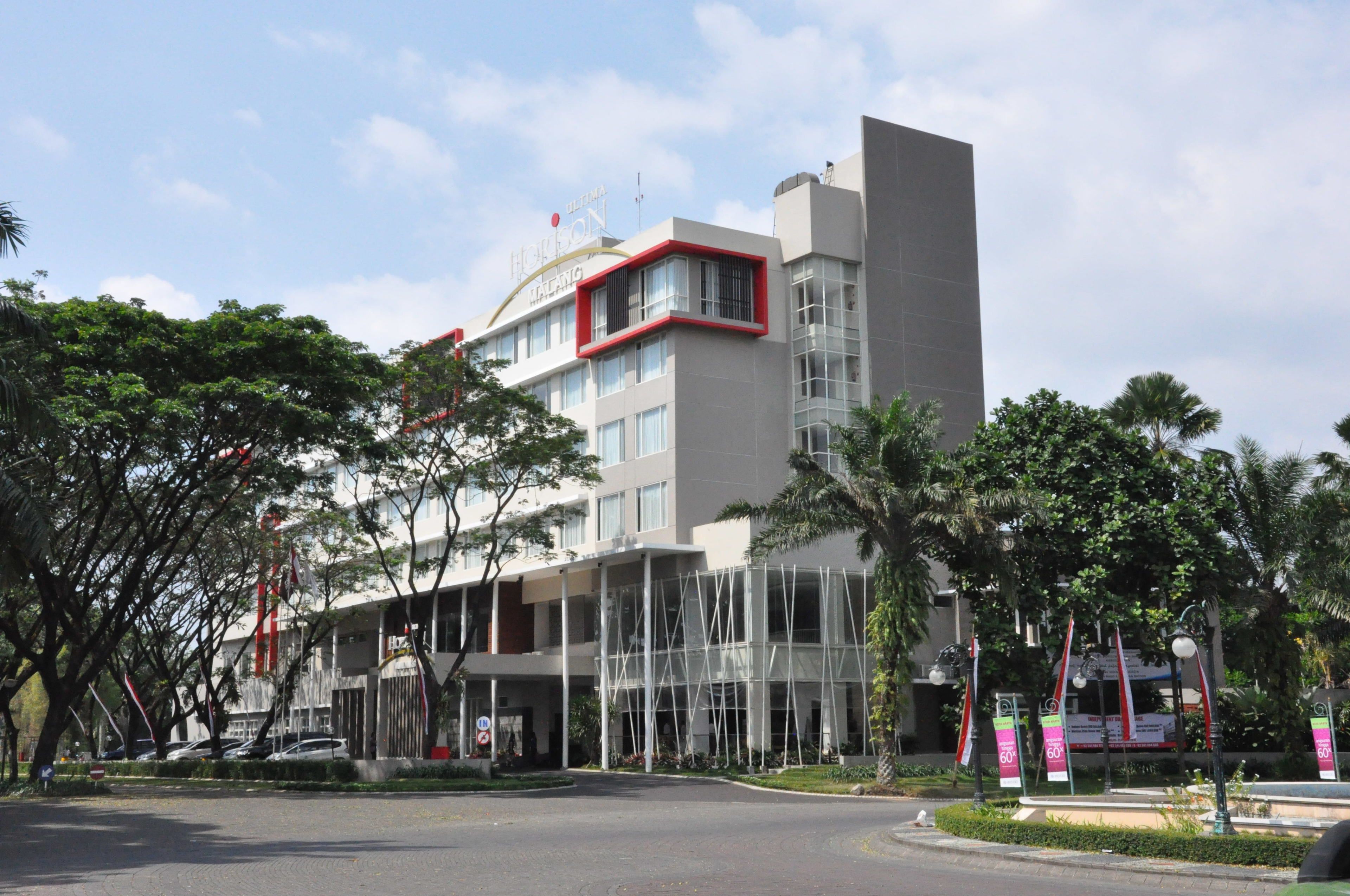 A modern hotel with a prominent entrance, multiple floors, and a mix of glass and concrete architecture.