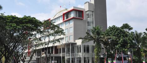 A modern hotel with a prominent entrance, multiple floors, and a mix of glass and concrete architecture.